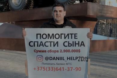 Дмитрий Дук стоит с плакатом в поддержку сына. Апреяль 2026 года, Жодино. Скриншот видео